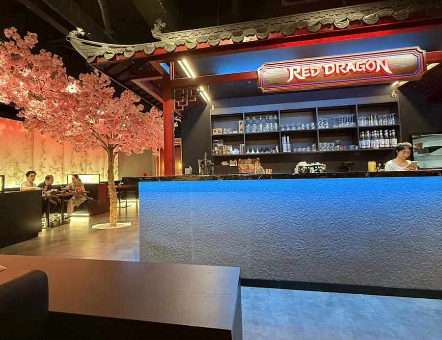The illuminated Red Dragon sign above the bar, with the cherry blossom tree in the dining room.